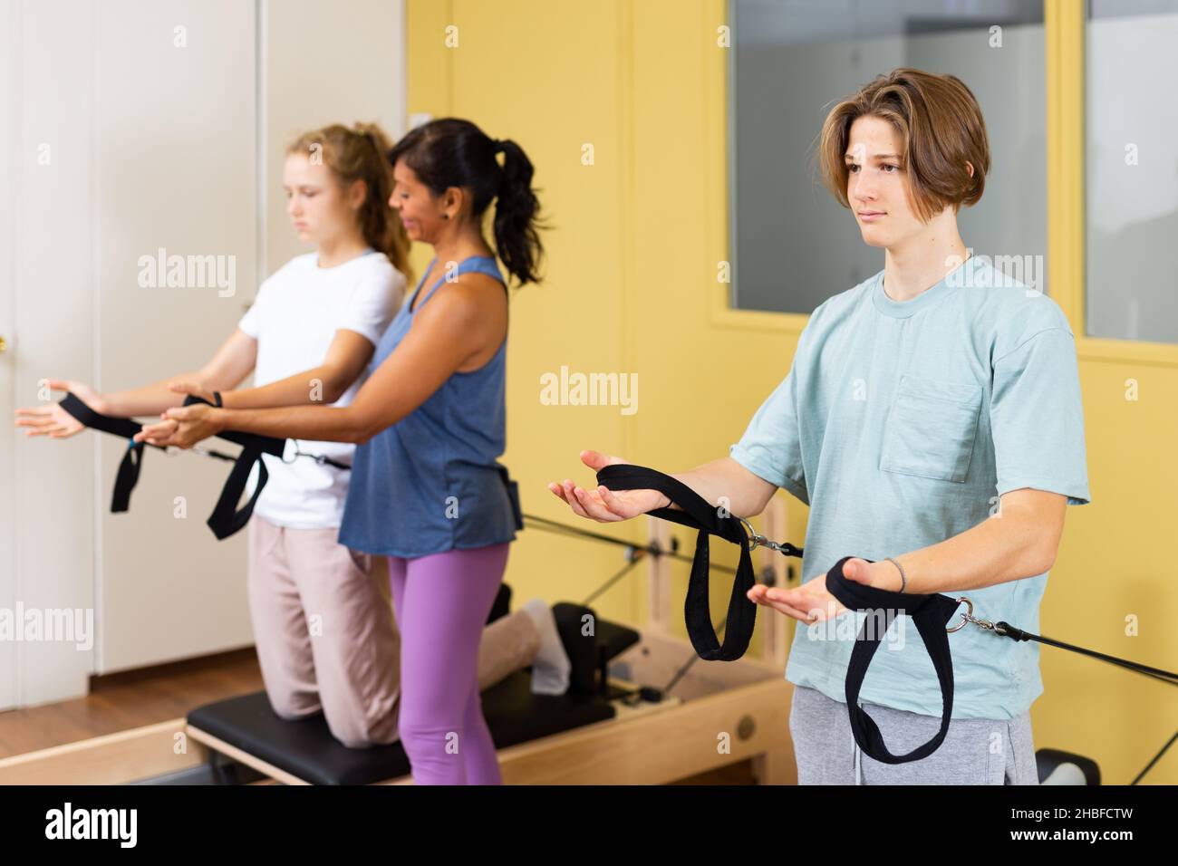 Adolescents d'entraînement pilates dans la salle de gym avec entraîneur Banque D'Images