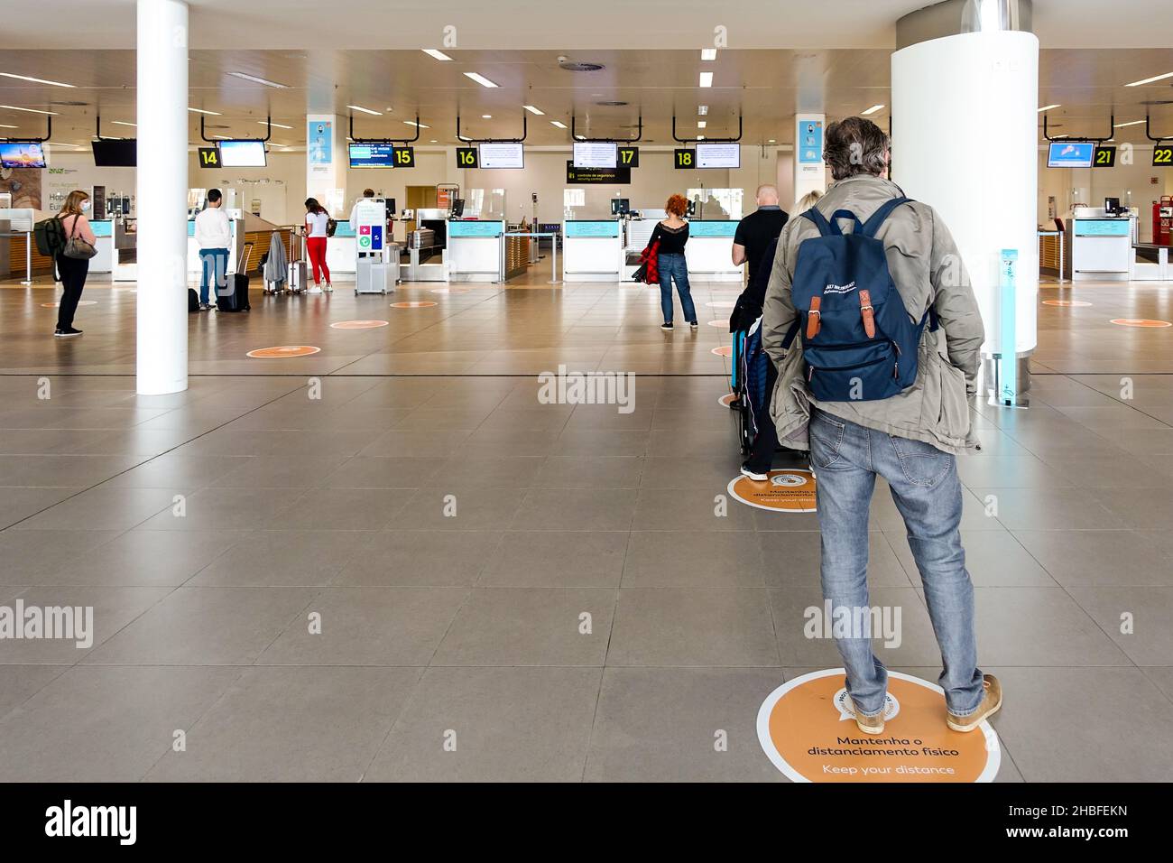 Des panneaux « Keep Your distance » s'indiquent à l'aéroport de Faro, au Portugal, car les voyageurs font la queue pour s'enregistrer pour leur vol Banque D'Images