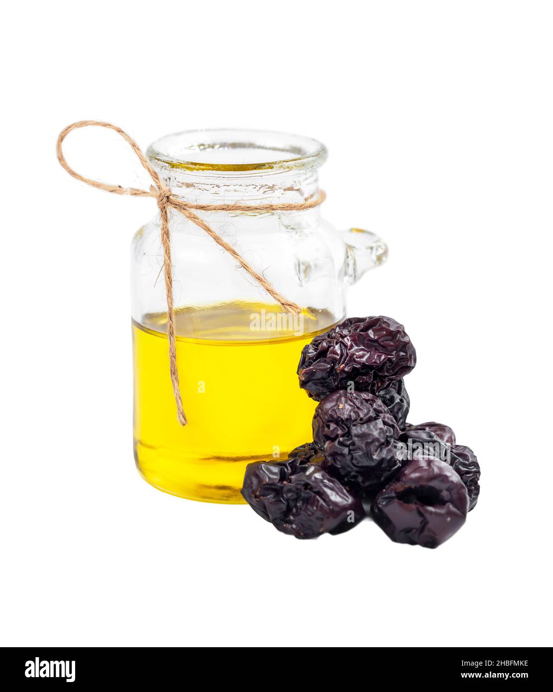 Jojoba séché et bouteille d'huile isolée sur fond blanc Banque D'Images