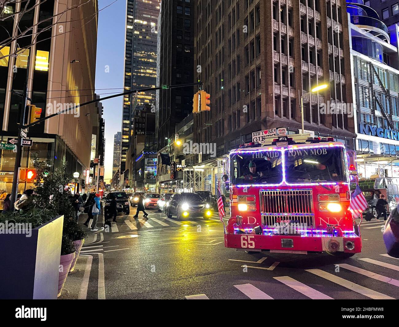 Un camion de feu FDNY décoré dans un éclairage de Noël et les mots « The Midtown Mob » sur le pare-brise tournent un coin à Manhattan, New York City Banque D'Images