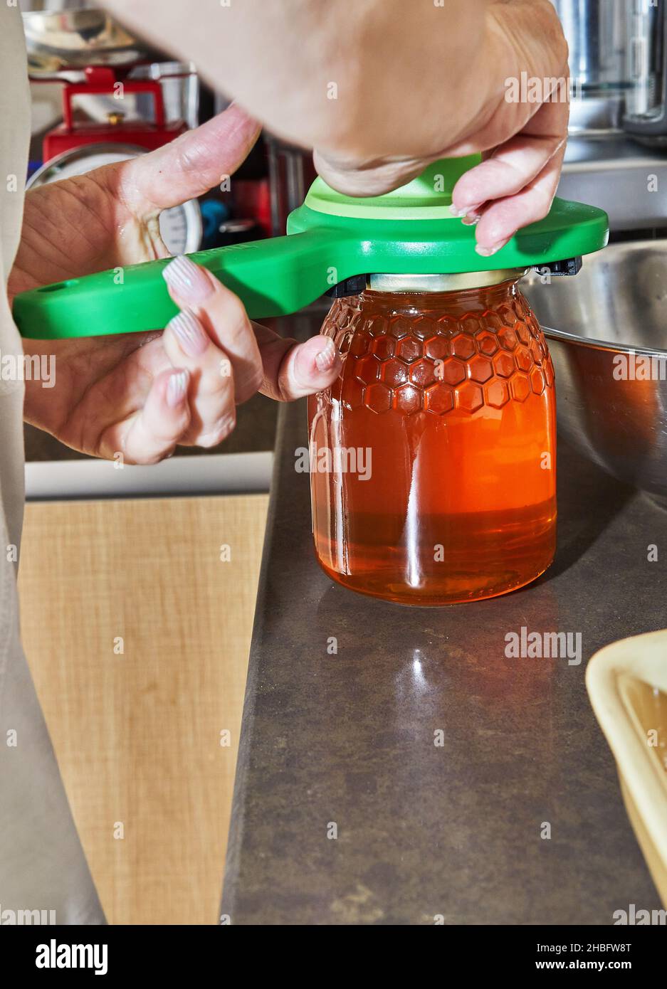 Le chef ouvre un pot de miel avec une clé spéciale Banque D'Images