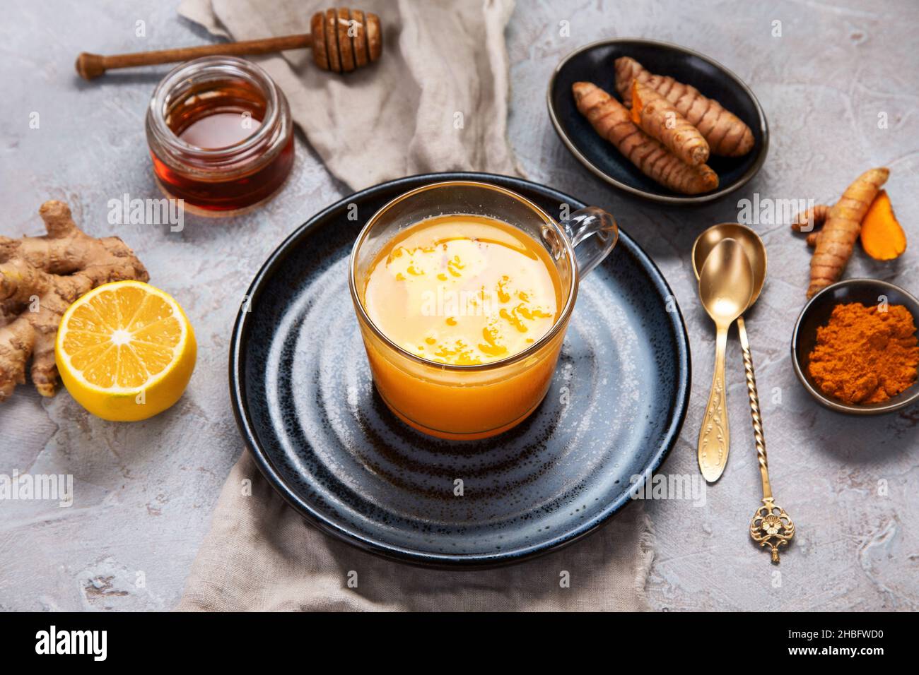 Thé doré curcuma sain sur fond gris clair.Boisson traditionnelle indienne. Banque D'Images