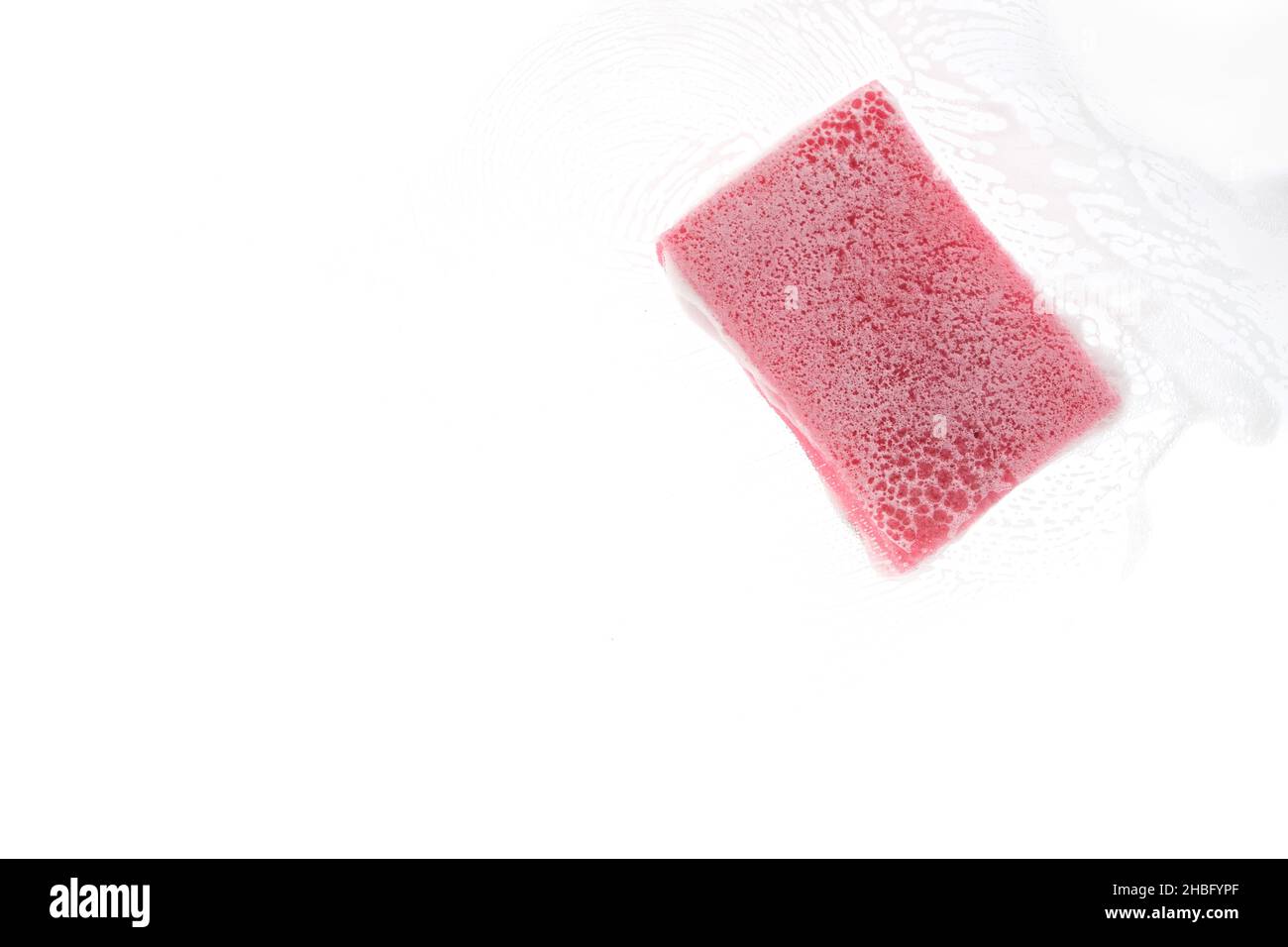Éponge pour laver la vaisselle sur verre transparent avec mousse Banque D'Images