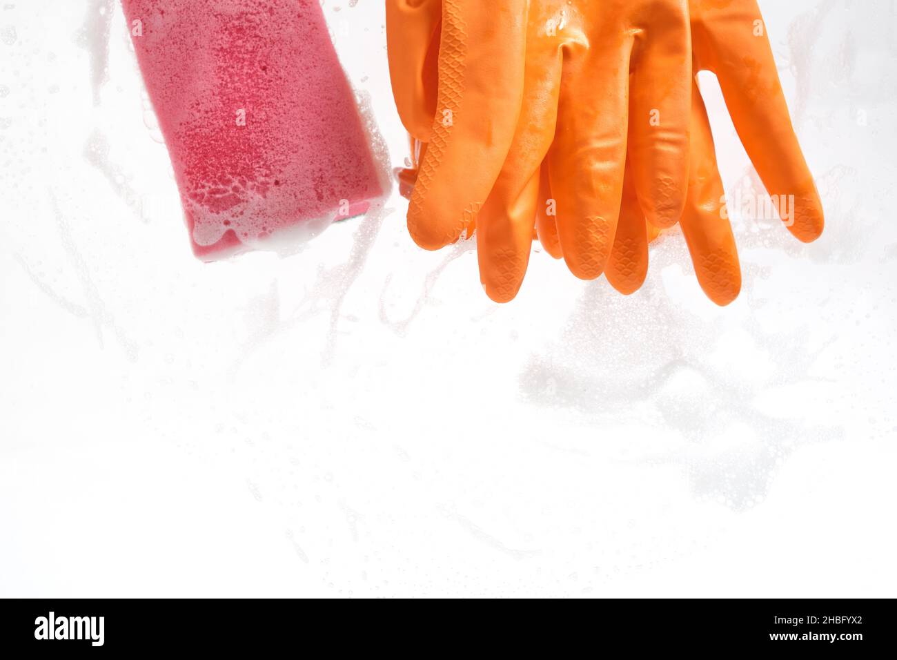 Gants avec éponge humide pour le nettoyage sur verre recouvert de mousse Banque D'Images