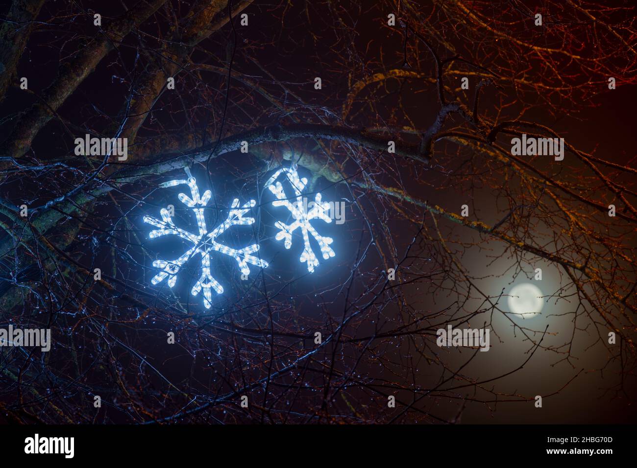 Des lumières de Noël en forme de flocon de neige à la tombée de la nuit.Chipping Norton, Cotswolds, Oxfordshire, Angleterre Banque D'Images