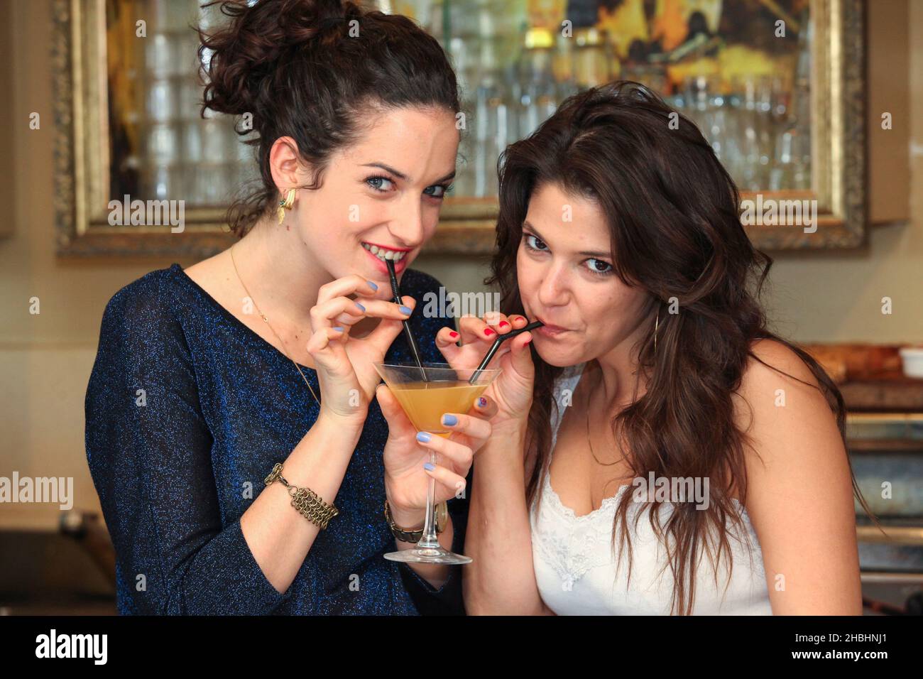 Deux jeunes femmes partagent un cocktail Banque D'Images