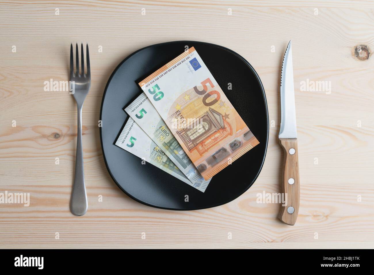 Studio conceptuel de la table de dîner avec des billets de banque euro sur l'assiette au lieu de la nourriture.Concept de la hausse des prix alimentaires, de l'inflation, de la crise économique Banque D'Images