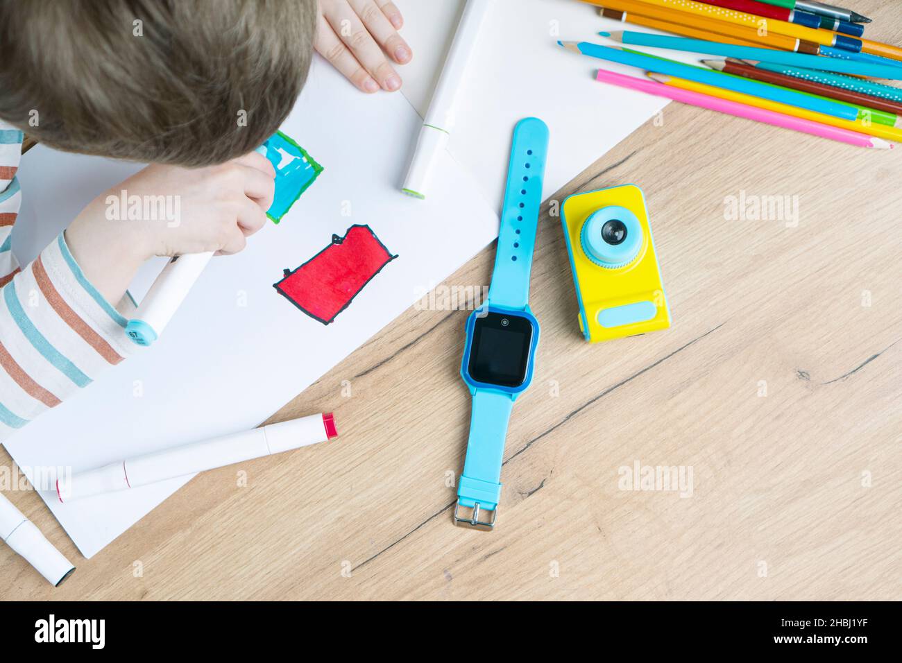 Montres Intelligentes Pour Bebe Avec Ecoute Surveillance A Distance Et Gps Tracker Sur La Table Pres De L Enfant Dans La Maternelle Le Garcon Dessine Dans L Album Photo Stock Alamy