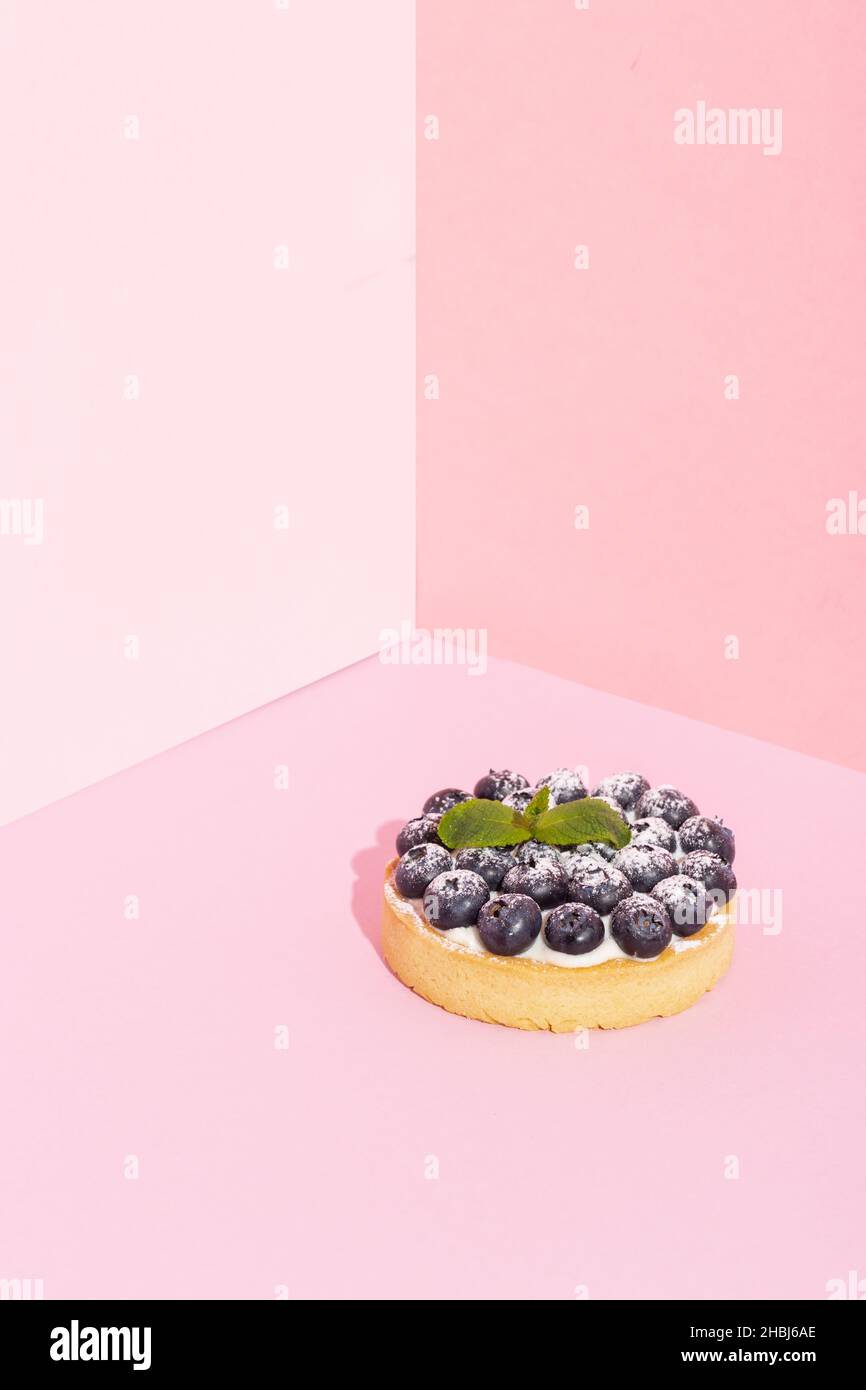 Gros plan sur des tartes de dessert aux myrtilles fraîches et luxueuses sur du rose Banque D'Images