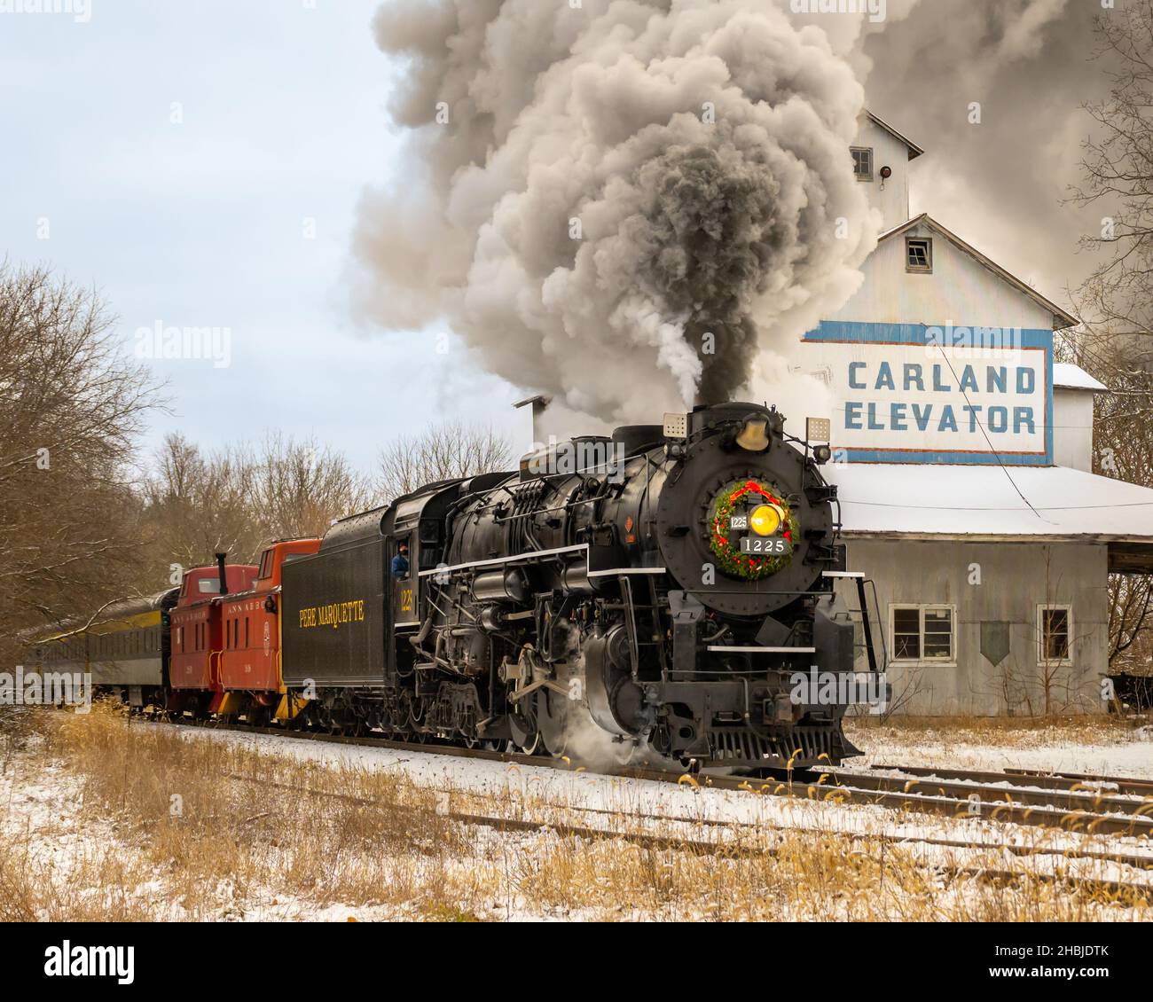 Célèbre North Pole Express (aliasMichigan Polar Express) - les chopes de locomotive à vapeur Pere Marquette 1225 devant l'élévateur Carland (élévateur de grain). Banque D'Images