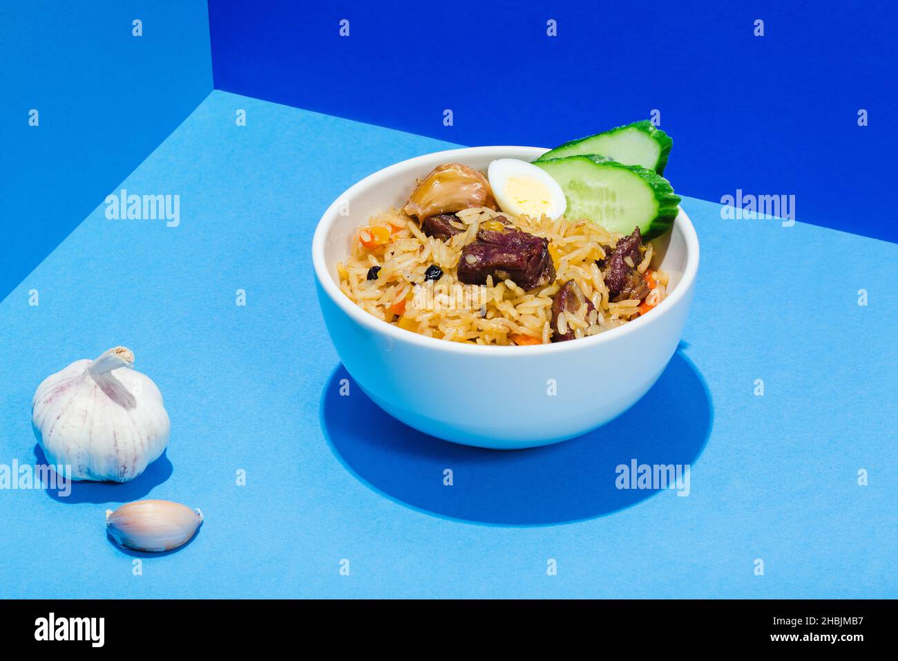 Cuisine orientale ouzbek traditionnelle riz à la viande plav sur cheveux bleus ombre de style moderne. Banque D'Images