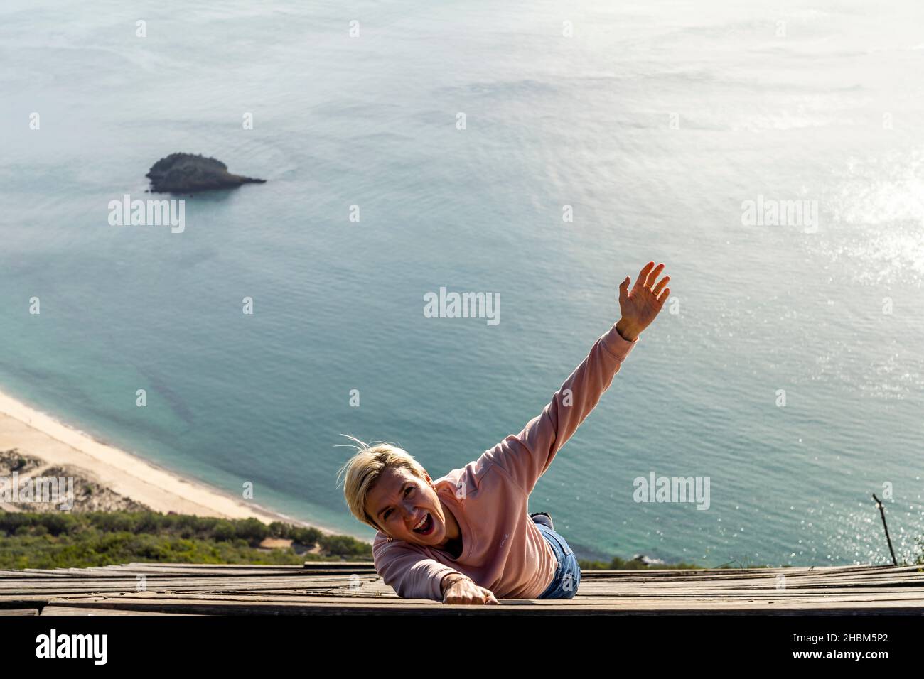 Femme tombant du haut dans l'océan, Miradouro do Portinho da Arrabida, Portugal Banque D'Images