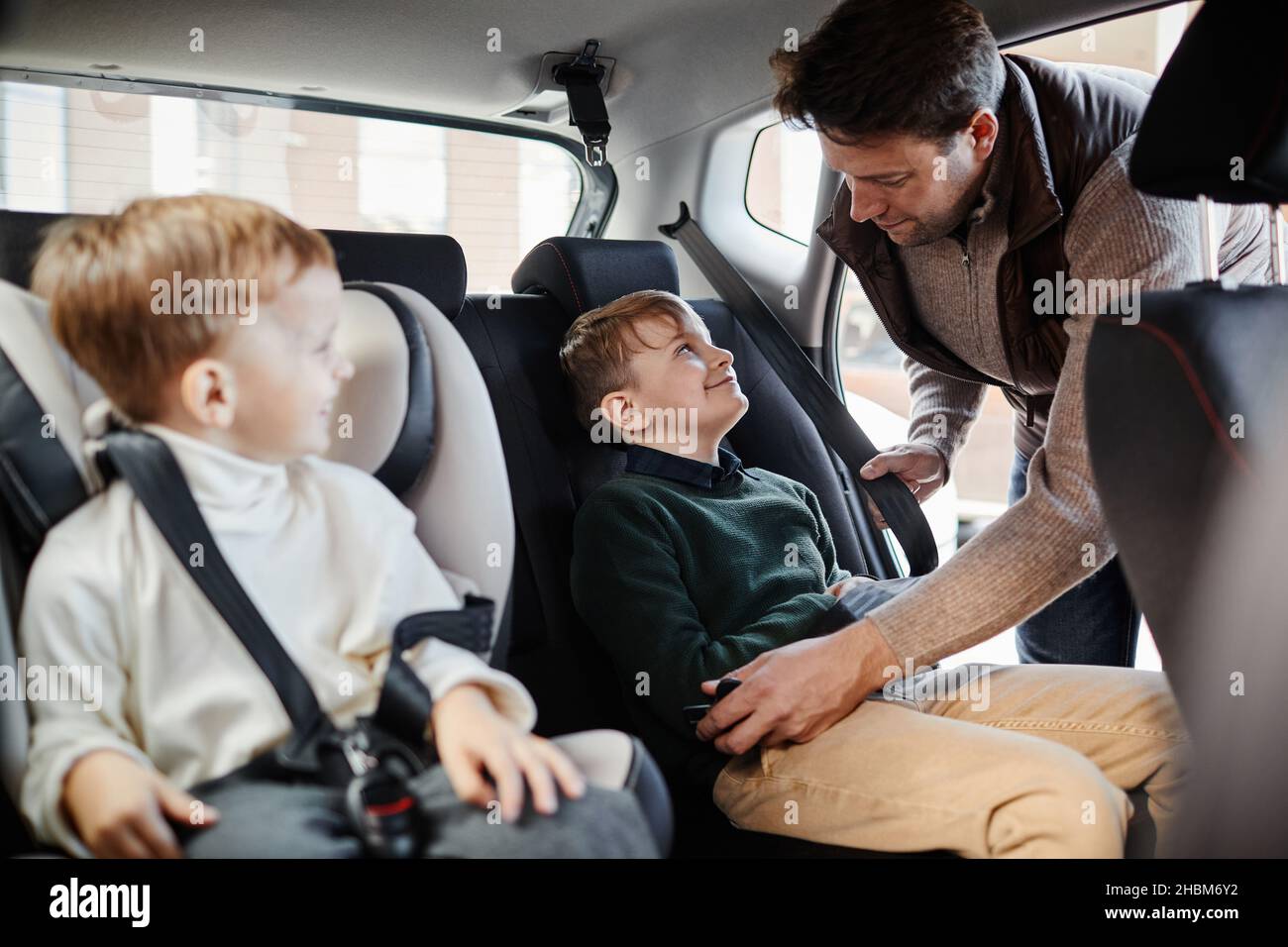 Portrait d'un homme qui flamber son dans le siège arrière de la voiture familiale, espace de copie Banque D'Images