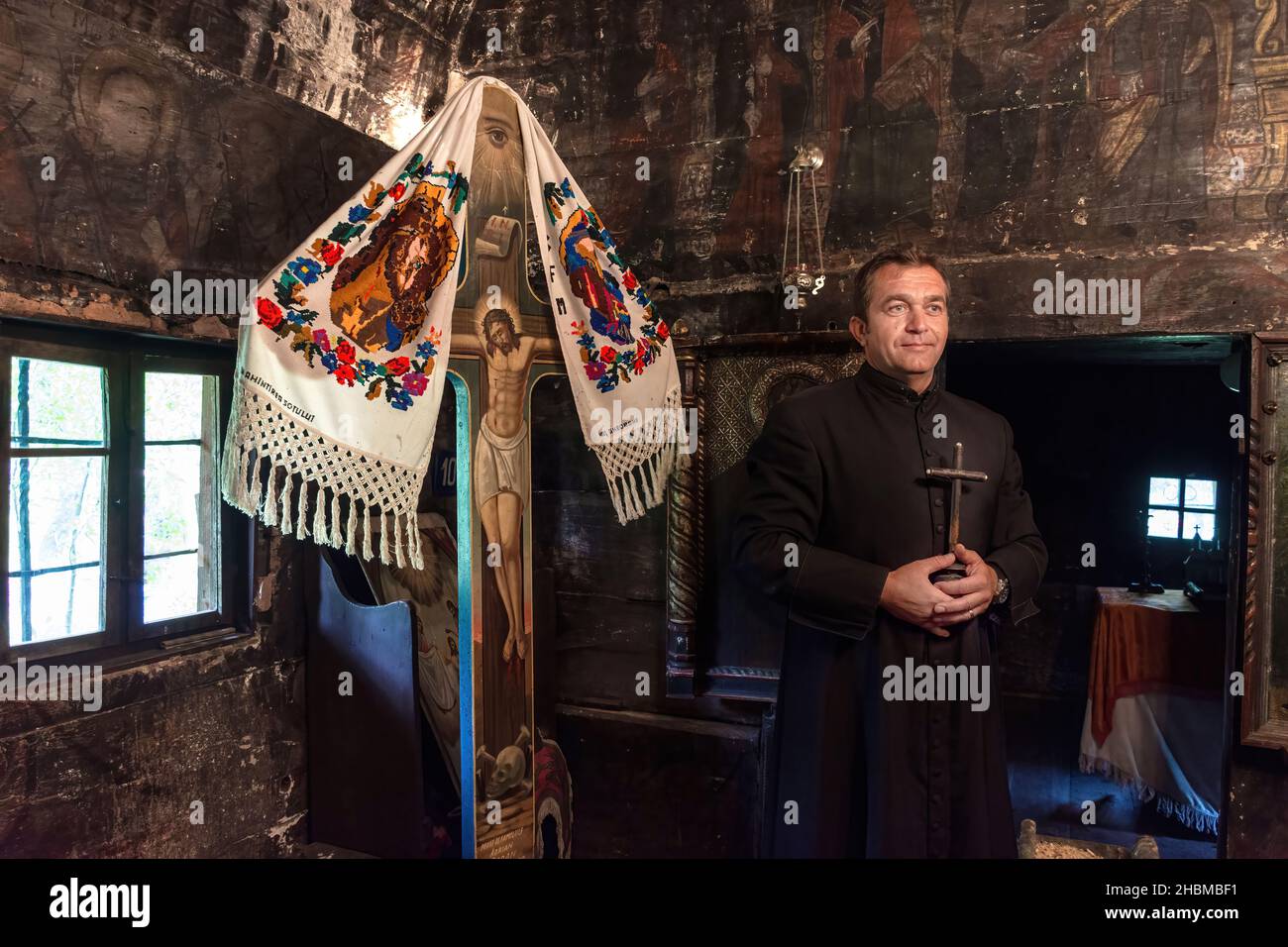 Salaj, Roumanie-16 mai 2018 : prêtre orthodoxe tenant une croix chrétienne, priant dans une ancienne église en bois de la région de Transylvanie, Roumanie. Banque D'Images