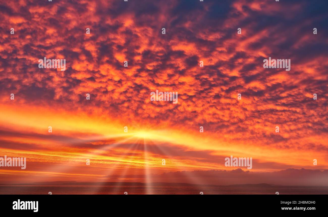 Ciel de lever de soleil spectaculaire dans des couleurs vives, jaune, orange et rouge avec soleil et rayons de soleil.Remplacement du SKY. Banque D'Images