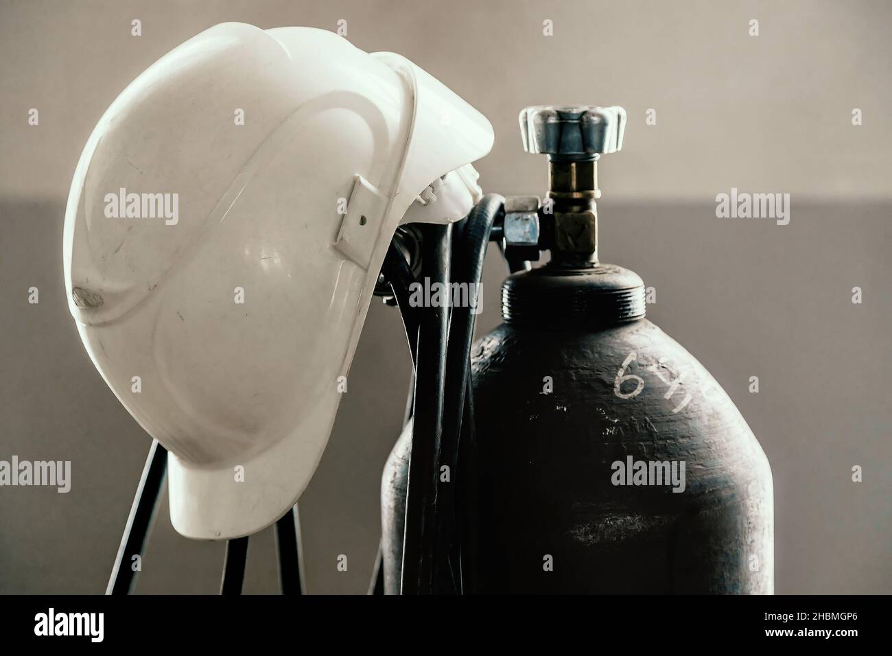 Le casque de construction est porté sur la bouteille d'oxygène dans l'atelier de soudage.Industrie et construction.Arrière-plan. Banque D'Images
