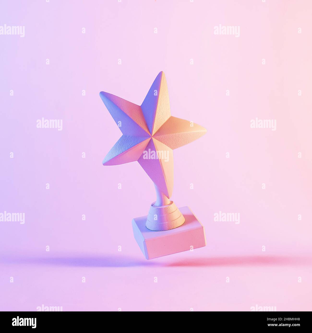 Modèle de trophée cinq étoiles pointues à l'envers.3D, planant dans un arrière-plan rose vif avec des ombres Banque D'Images