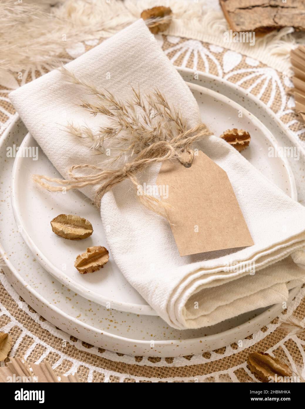 Table de mariage avec étiquette cadeau vierge attachée à une serviette sur  un placarat bohème gros plan.Maquette d'étiquette de boho.Modèle beige  tropical avec pla séché Photo Stock - Alamy