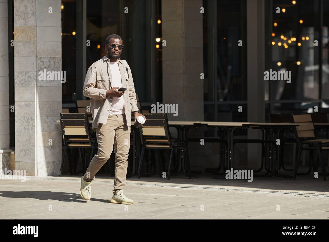 Portrait complet de l'homme afro-américain adulte marchant dans la rue de la ville urbaine, espace de copie Banque D'Images