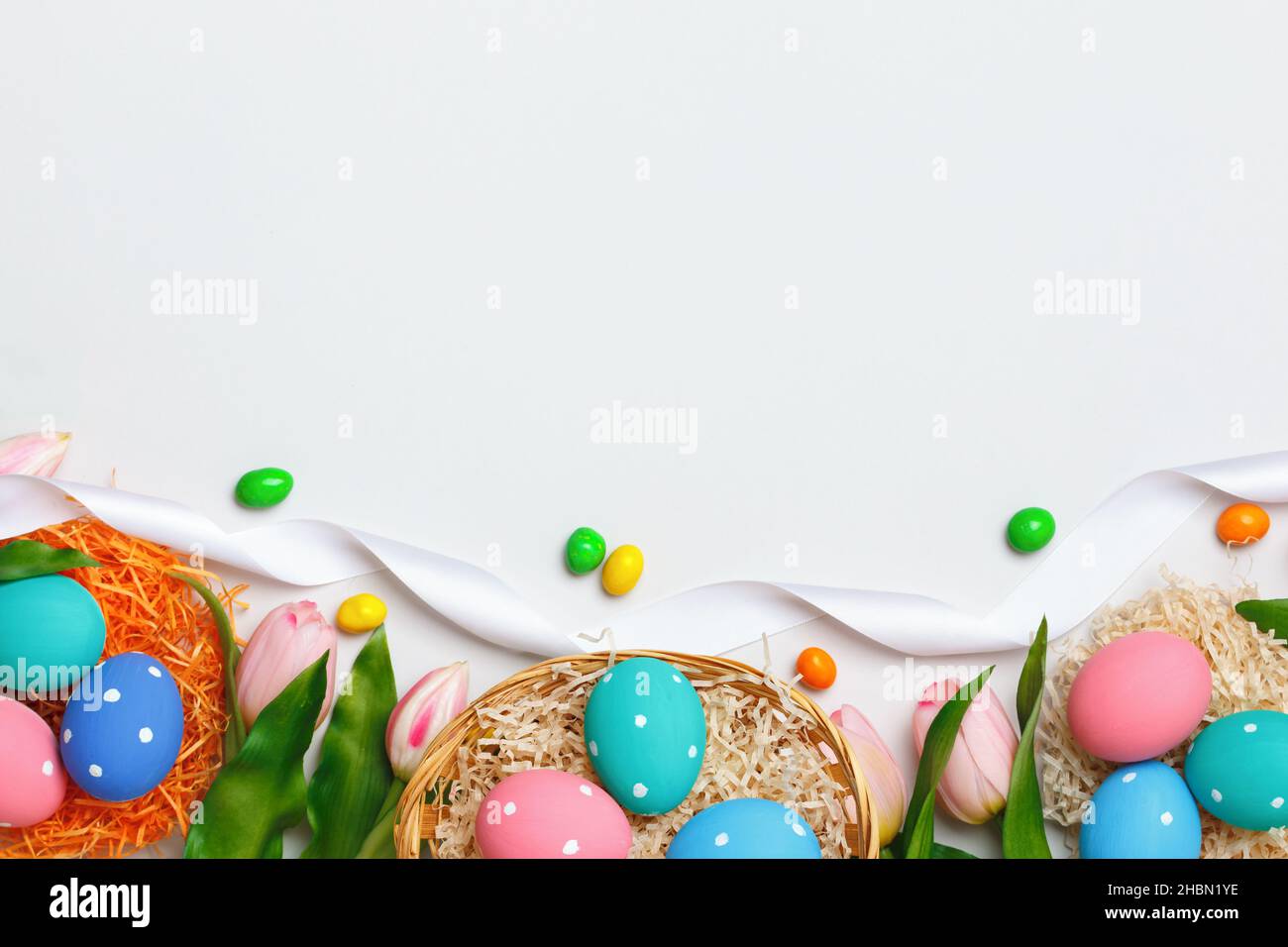 Composition de Pâques sur fond gris.Tulipes panier d'œufs.Cadre de la bannière cadre plat plan plan plan vue du dessus espace de copie Banque D'Images
