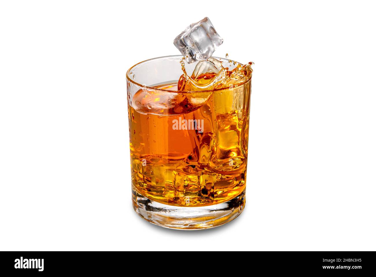 Verre de Whiskey, whisky ou bourbon avec glaçons tombant avec éclaboussures, isolé sur blanc Banque D'Images
