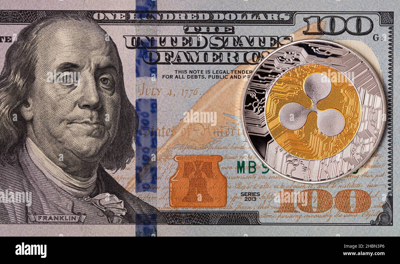 Ripple coin, jeton XRP, crypto-monnaie sur un fond de 100 dollars US à des  fins de conception Photo Stock - Alamy