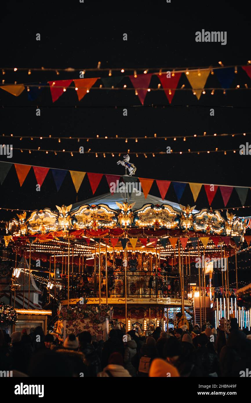 Manège manège pour enfants magiques Joyeux dans l'atmosphère du nouvel an avec des gens qui marchent et des guirlandes festives.Vacances magiques à Moscou. Vertical po Banque D'Images