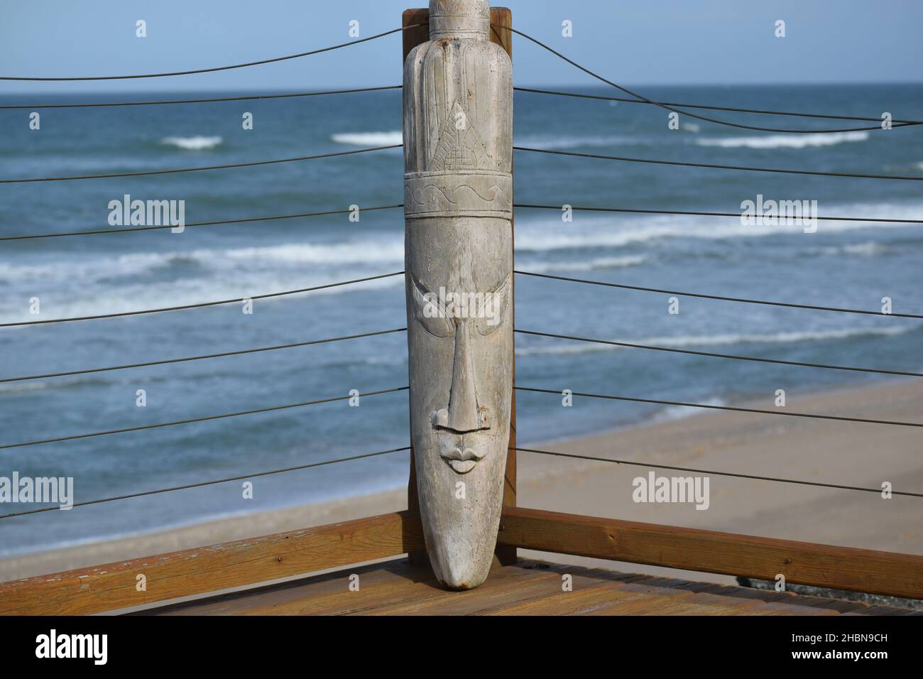 Un visage Tiki en bois sculptant avec fond d'océan. Banque D'Images