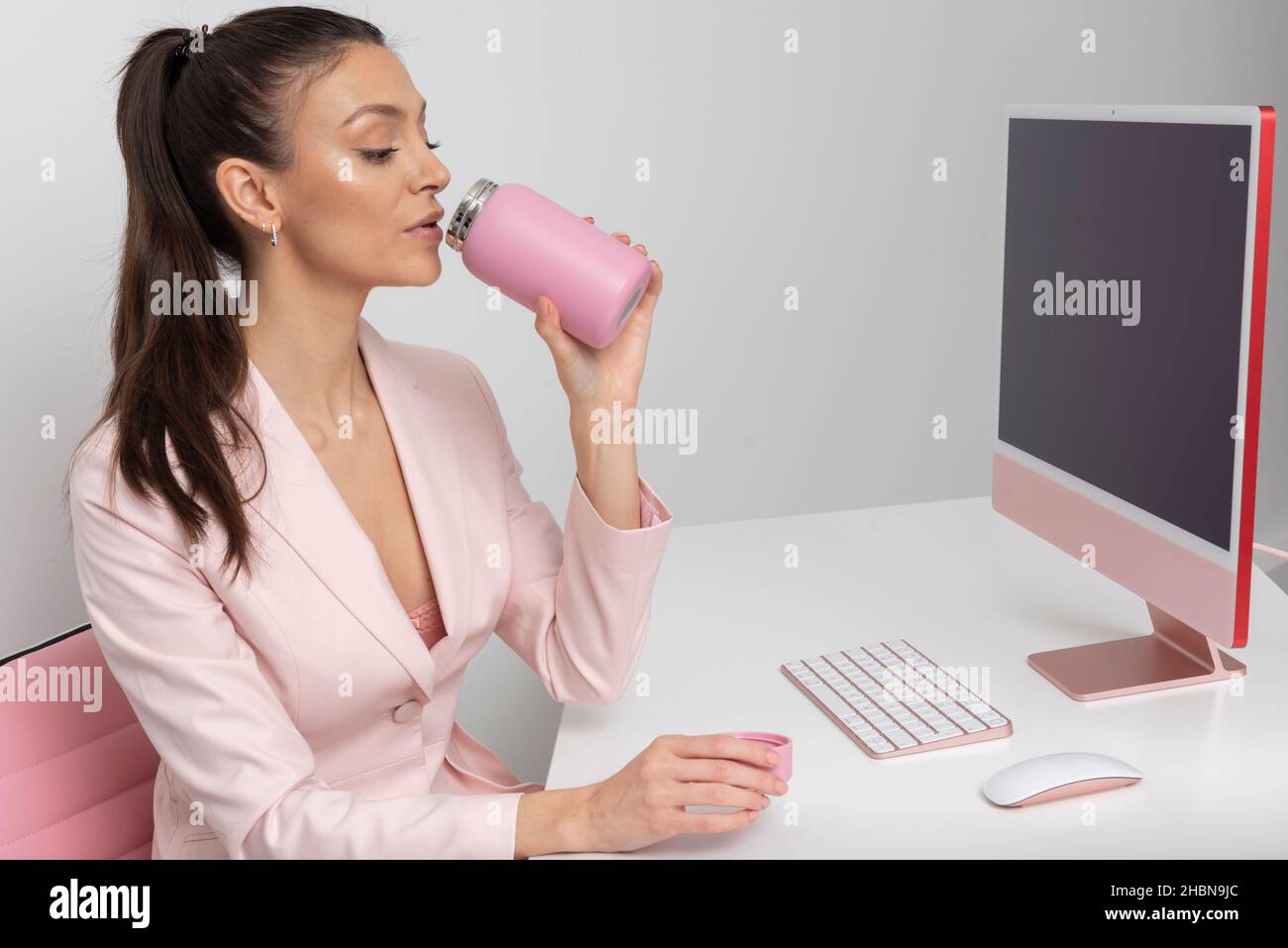 Salisbury, Royaume-Uni.2021. Une employée de bureau boit dans une fiole rose Banque D'Images