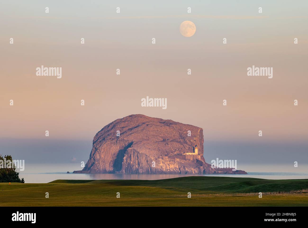 Bass Rock avec voile et voile et pleine lune au coucher du soleil, Firth of Forth, Écosse, Royaume-Uni Banque D'Images