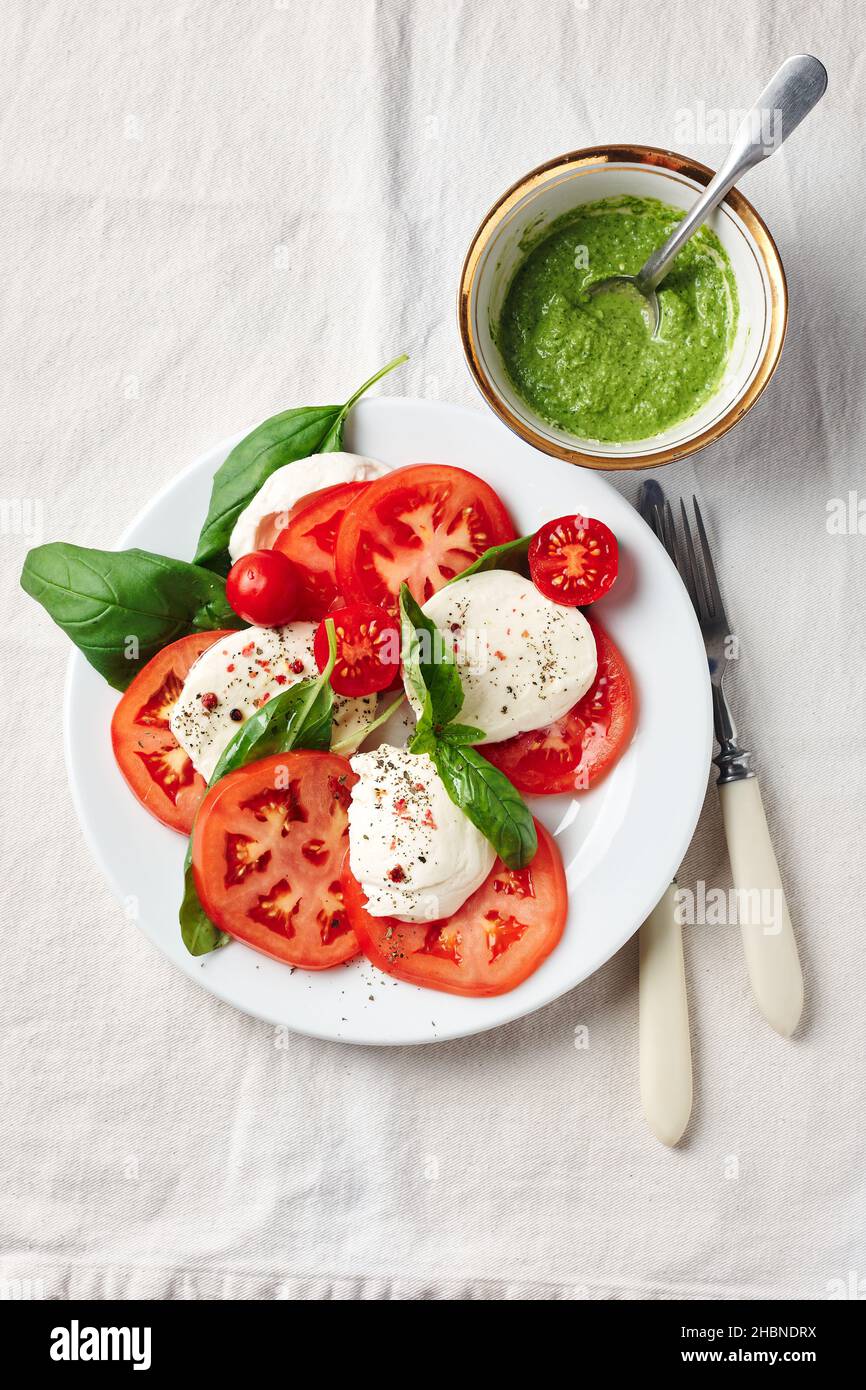 Salade Caprese. Tomates, fromage mozzarella, feuilles de basilic et sauce pesto. Banque D'Images
