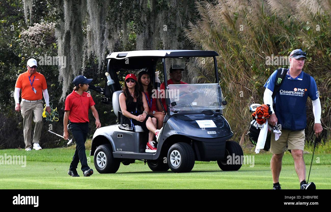 Orlando, États-Unis.19th décembre 2021.Tiger Woods conduit une voiturette de golf avec les passagers Sam Woods (au centre) et Erica Herman, tandis que son fils Charlie Woods marche le long du neuvième trou, lors de la dernière partie du championnat PNC au Ritz-Carlton Golf Club Grande Lakes à Orlando.Tiger et Charlie ont établi un record de tournoi avec 11 birdies consécutives dimanche, en tirant un 15-under-par 57 et en terminant deuxième dans le tournoi de 36 trous.Crédit : SOPA Images Limited/Alamy Live News Banque D'Images