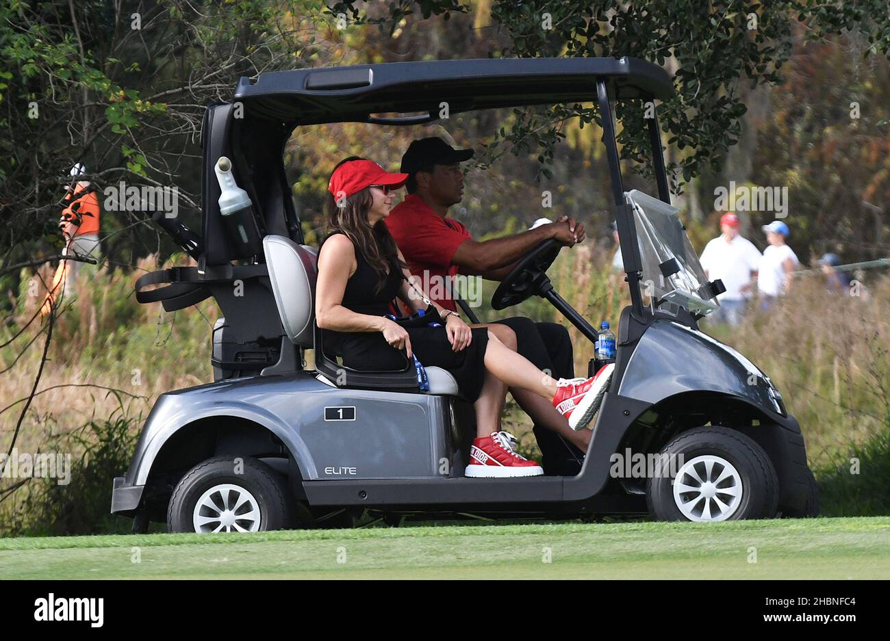 Orlando, États-Unis.19th décembre 2021.Tiger Woods conduit une voiturette de golf avec des passagers, sa fille Sam Woods (obscurci) et sa petite amie, Erica Herman, sur le neuvième trou lors de la dernière partie du championnat PNC au Ritz-Carlton Golf Club Grande Lakes à Orlando.Tiger et son fils, Charlie Woods, ont établi un record de tournoi avec 11 birdies consécutifs dimanche, en tirant un 15-under-par 57 et en terminant deuxième dans le tournoi de 36 trous.Crédit : SOPA Images Limited/Alamy Live News Banque D'Images