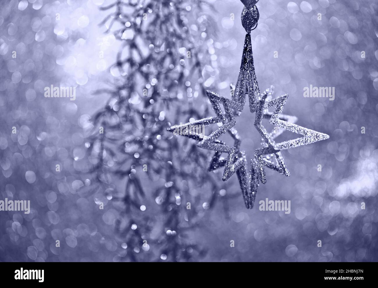 Décoration de Noël étoile argentée et lumières sur fond violet flou Banque D'Images