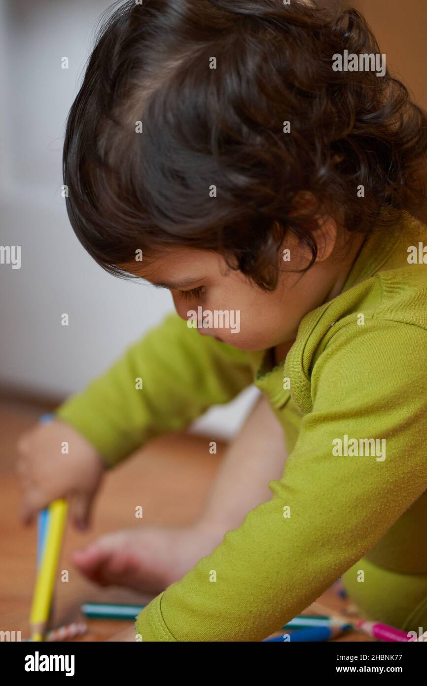 Enfant d'âge préscolaire tient des crayons dans ses mains pour dessiner. activités de jardin Banque D'Images