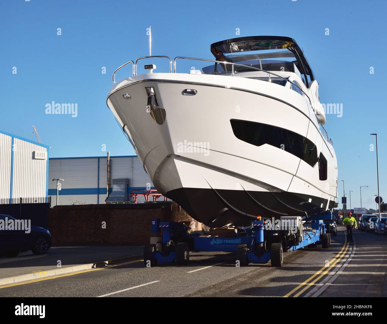 Un yacht de luxe Sunseeker est déplacé le long d'une route publique sur un chariot motorisé télécommandé à Poole, Dorset. Banque D'Images