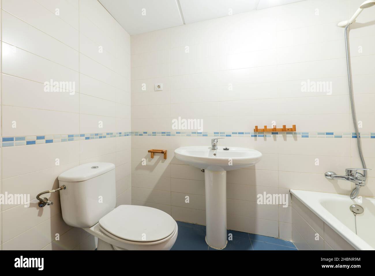 Toilettes avec lavabo blanc et baignoire et bordure en porcelaine bleue dans un appartement de location de vacances Banque D'Images