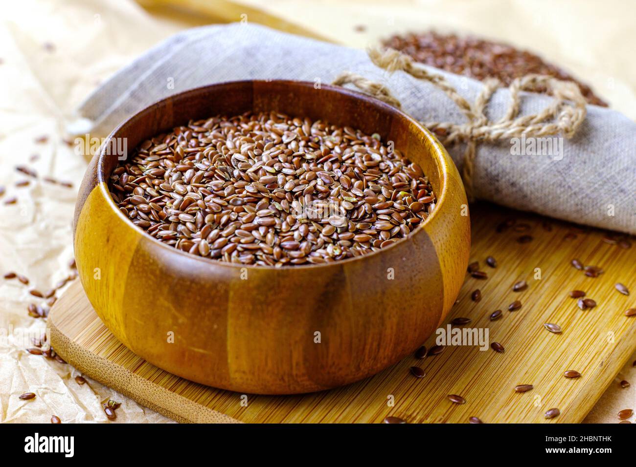 Faire dorer les graines de lin sèches dans une cuillère en bois et les mettre sur un fond clair. Banque D'Images