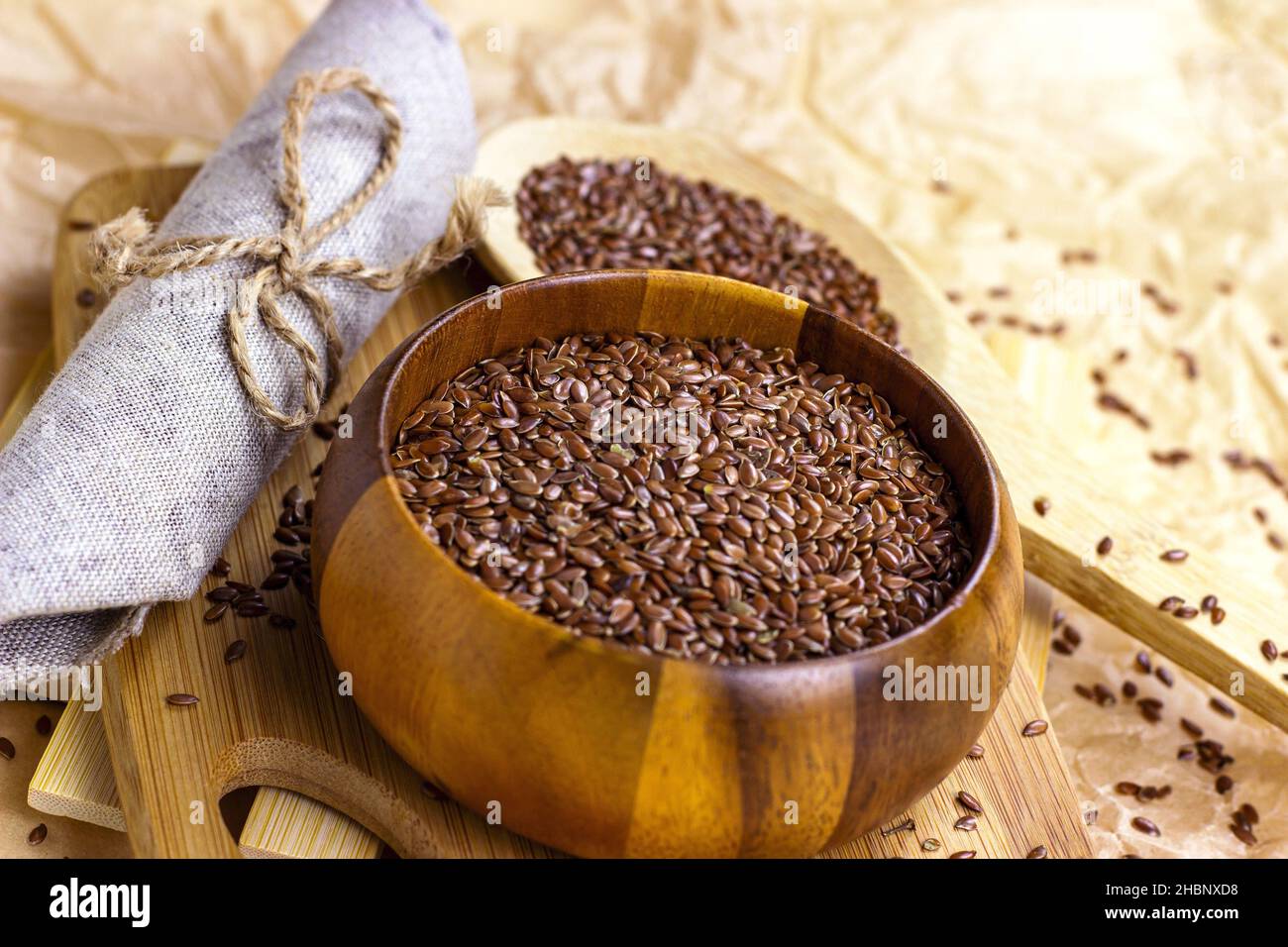 Faire dorer les graines de lin sèches dans une cuillère en bois et les mettre sur un fond clair. Banque D'Images