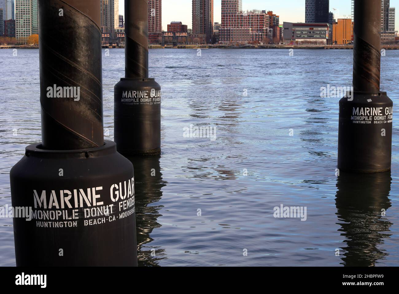 Garde-boue monopile Donut flottant dans la rivière East, NY. Des ailes flottantes de style donut protègent les navires contre les risques de collision avec le monopile marin Banque D'Images