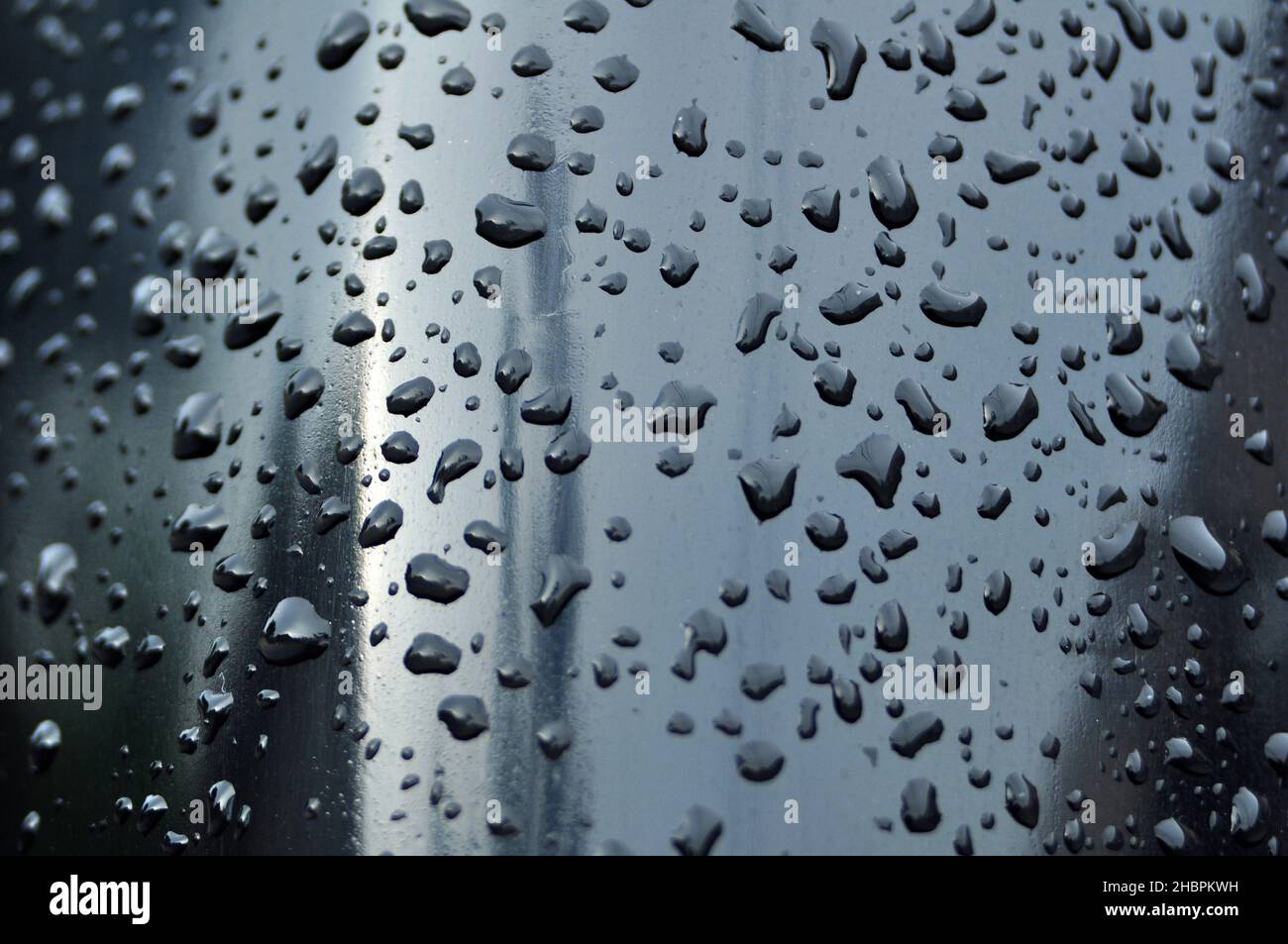 Les gouttelettes d'eau profonde sur la surface noire et certaines des gouttelettes d'eau sont floues Banque D'Images