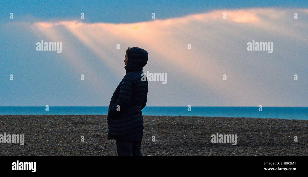 Brighton UK 21st décembre 2021 - le soleil se brise à travers les nuages le long du front de mer de Brighton par une matinée froide, car un temps humide plus doux est prévu pour le week-end de Noël : Credit Simon Dack / Alamy Live News Banque D'Images