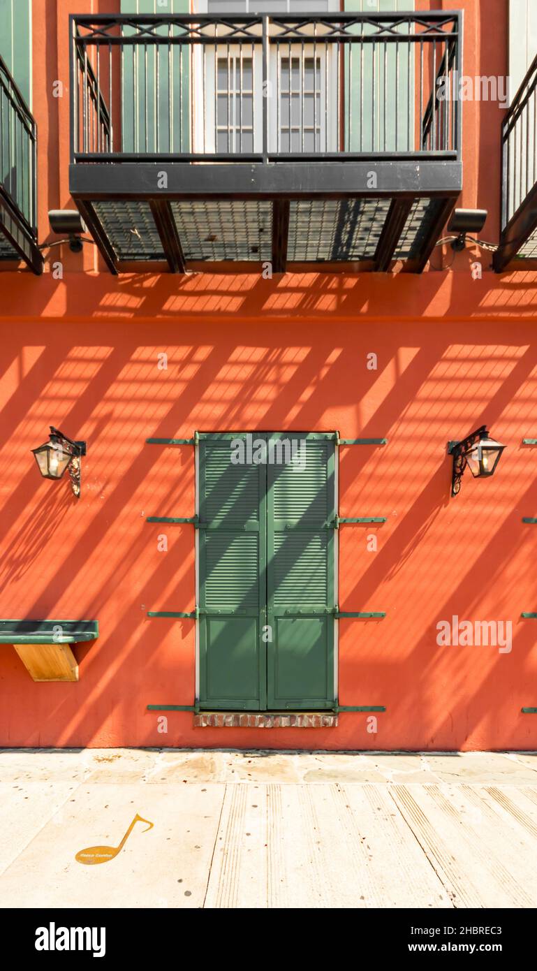 Portes à volets verts contre des murs orange-bruns avec des ombres diagonales abstraites à Memphis Tennessee Banque D'Images