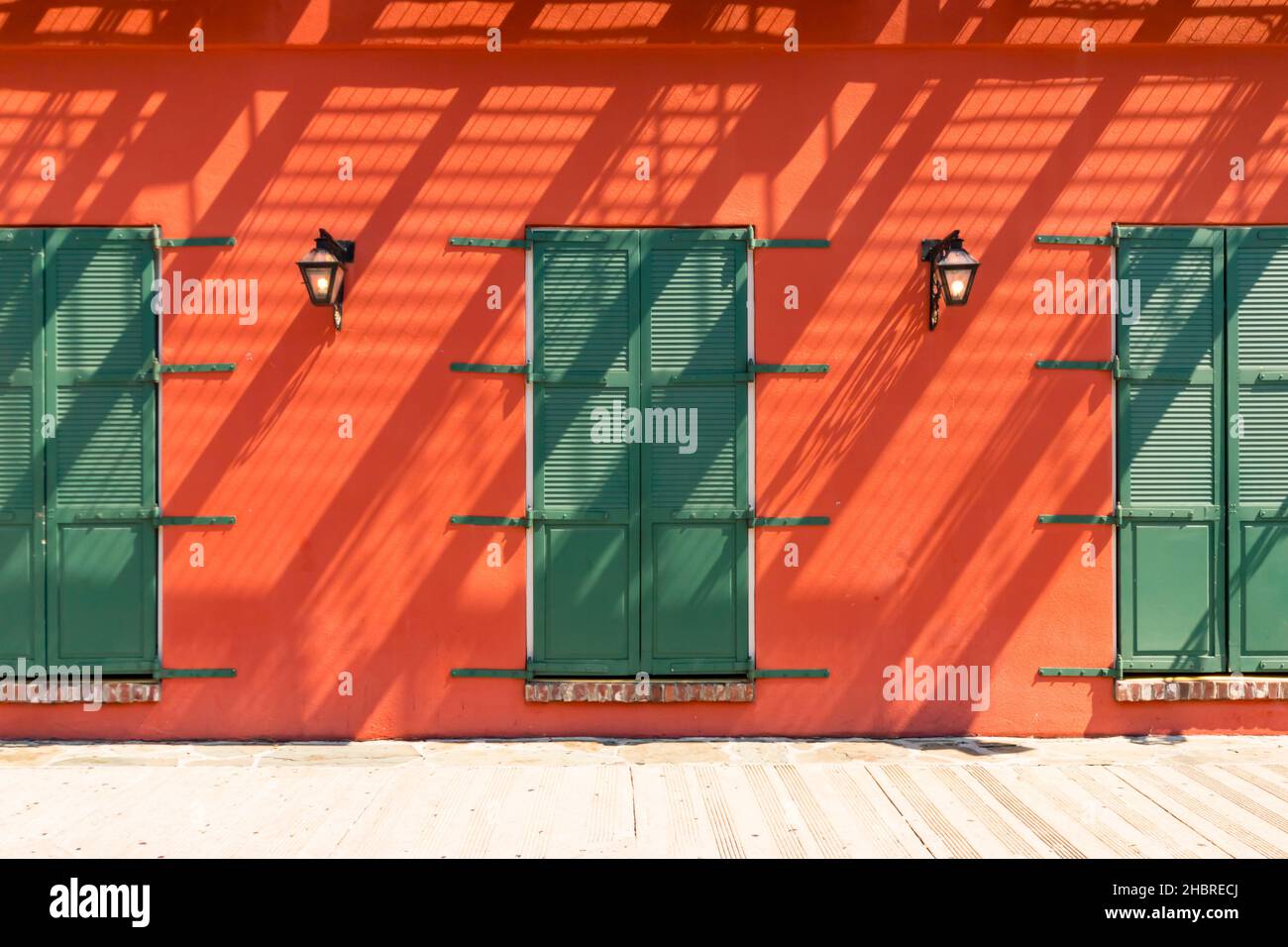 Portes à volets verts contre des murs orange-bruns avec des ombres diagonales abstraites à Memphis Tennessee Banque D'Images