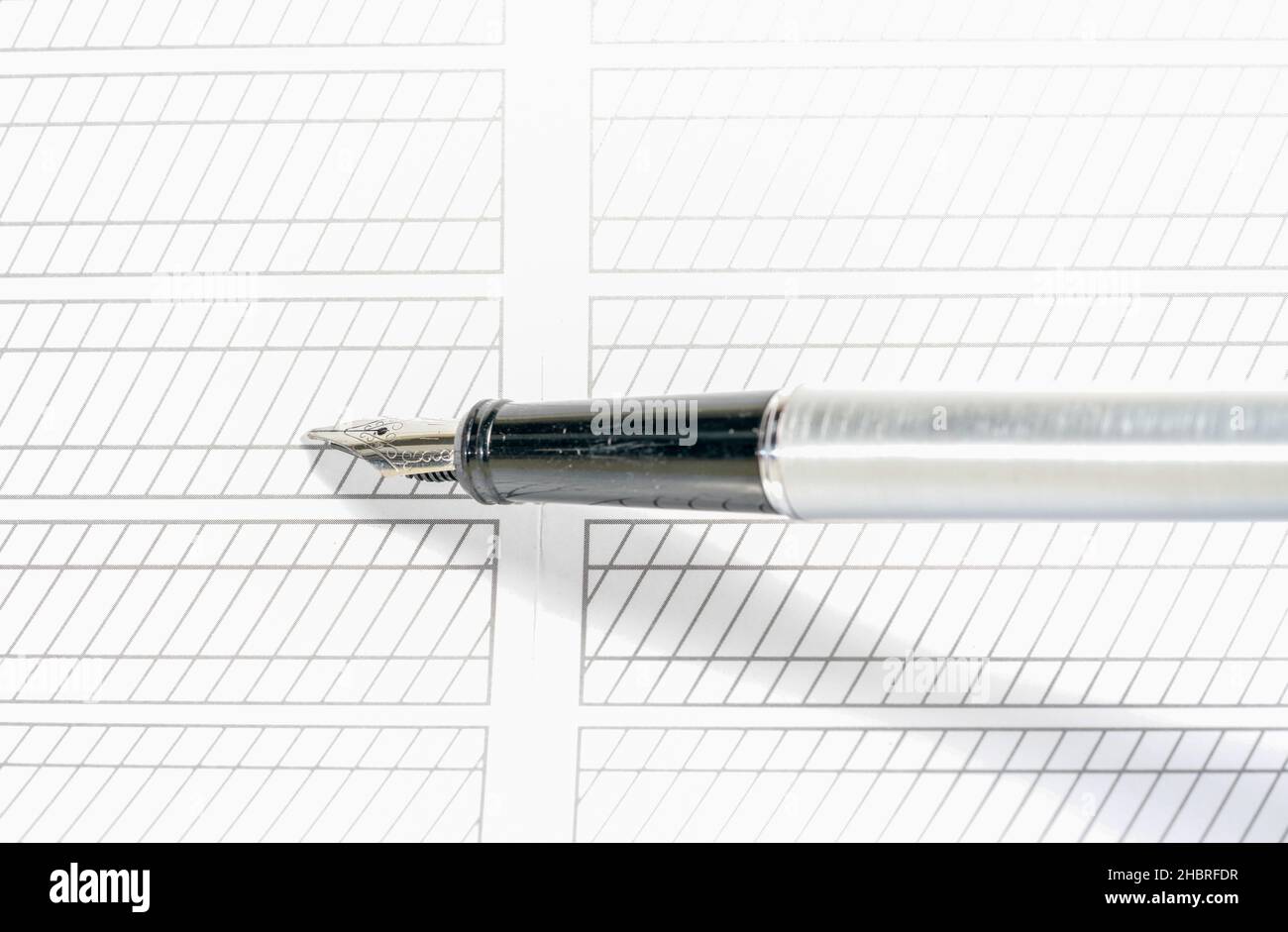 Gros plan d'un stylo dessinant des lignes géométriques sur un livre blanc Banque D'Images