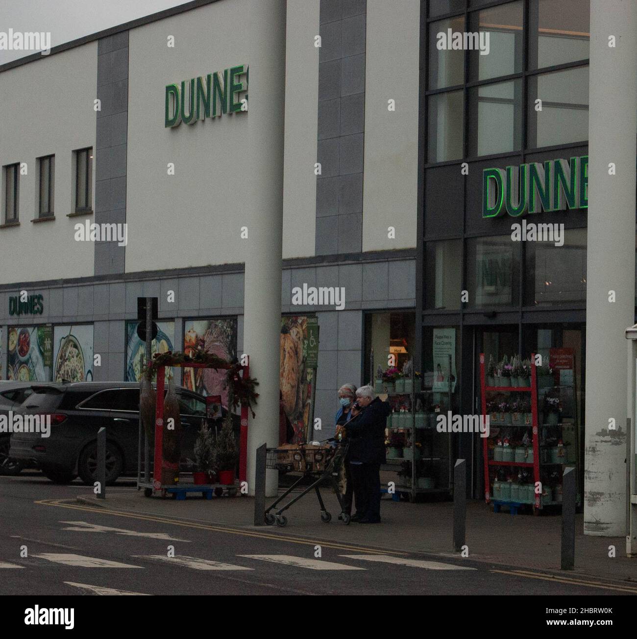 Macroom, Co. Cork Ireland, mardi 21 décembre 2021 ; les achats de Noël ont été en plein essor à Macroom avec des acheteurs qui ont obtenu leurs cadeaux de dernière minute et des bonnes affaires ainsi que des articles essentiels pour tenir la maison.La plupart des magasins et des détaillants, comme les magasins Dunnes, ont augmenté leurs heures de magasinage pour aider les gens à obtenir leurs articles de dernière minute et s'assurer que les mesures de distance sociale et toutes les directives sont respectées.Credit ED/Alamy Live News Banque D'Images