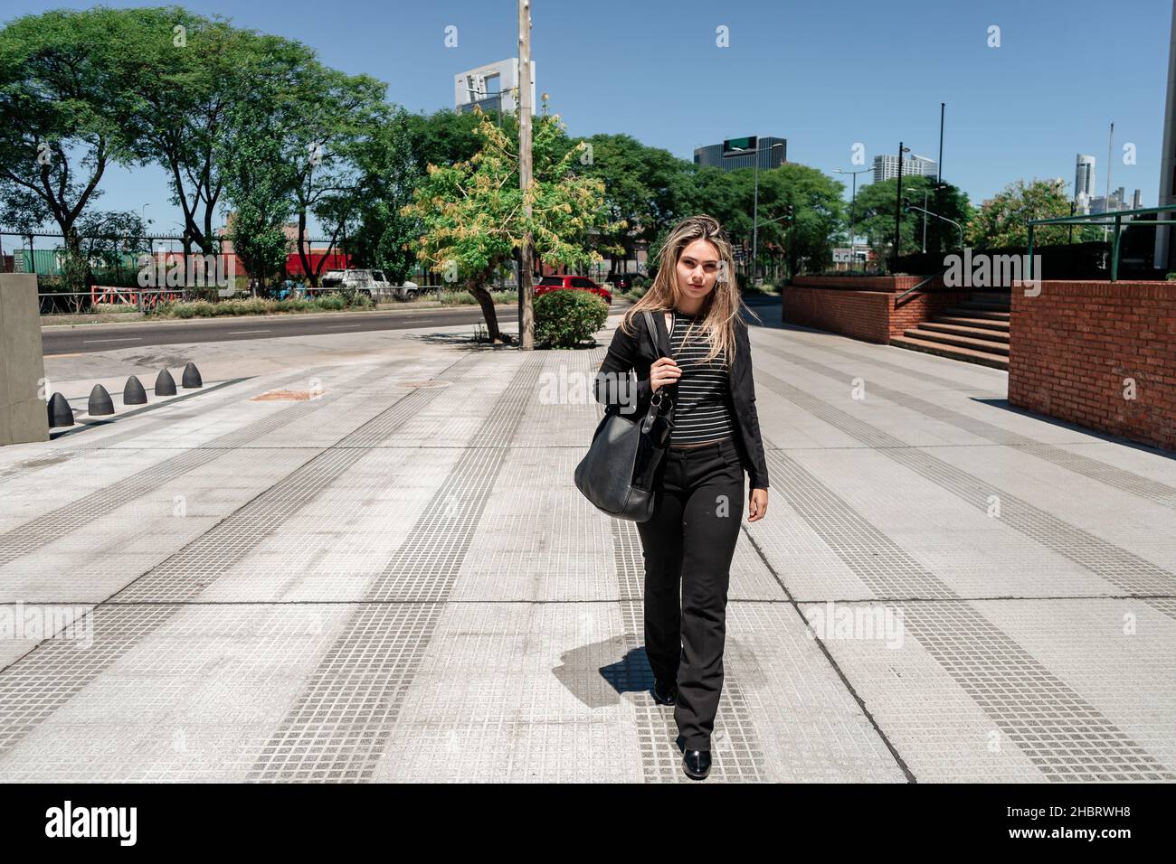Un portrait d'un bel entrepreneur de Latina marchant dans la ville par une journée ensoleillée. Banque D'Images