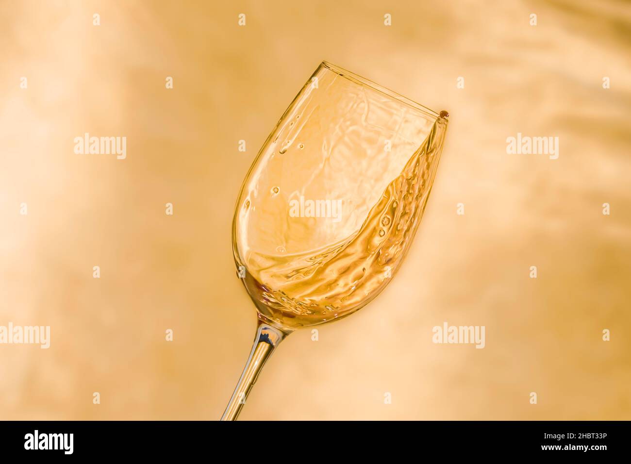 Un verre de vin appétissant sur fond doré Banque D'Images