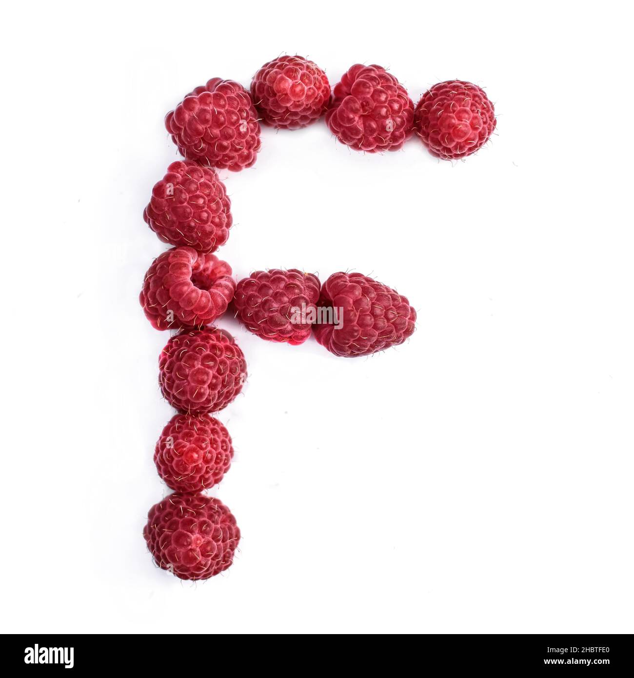 La lettre F de l'alphabet anglais de framboises mûres rouges, , s'isole sur un fond blanc Banque D'Images