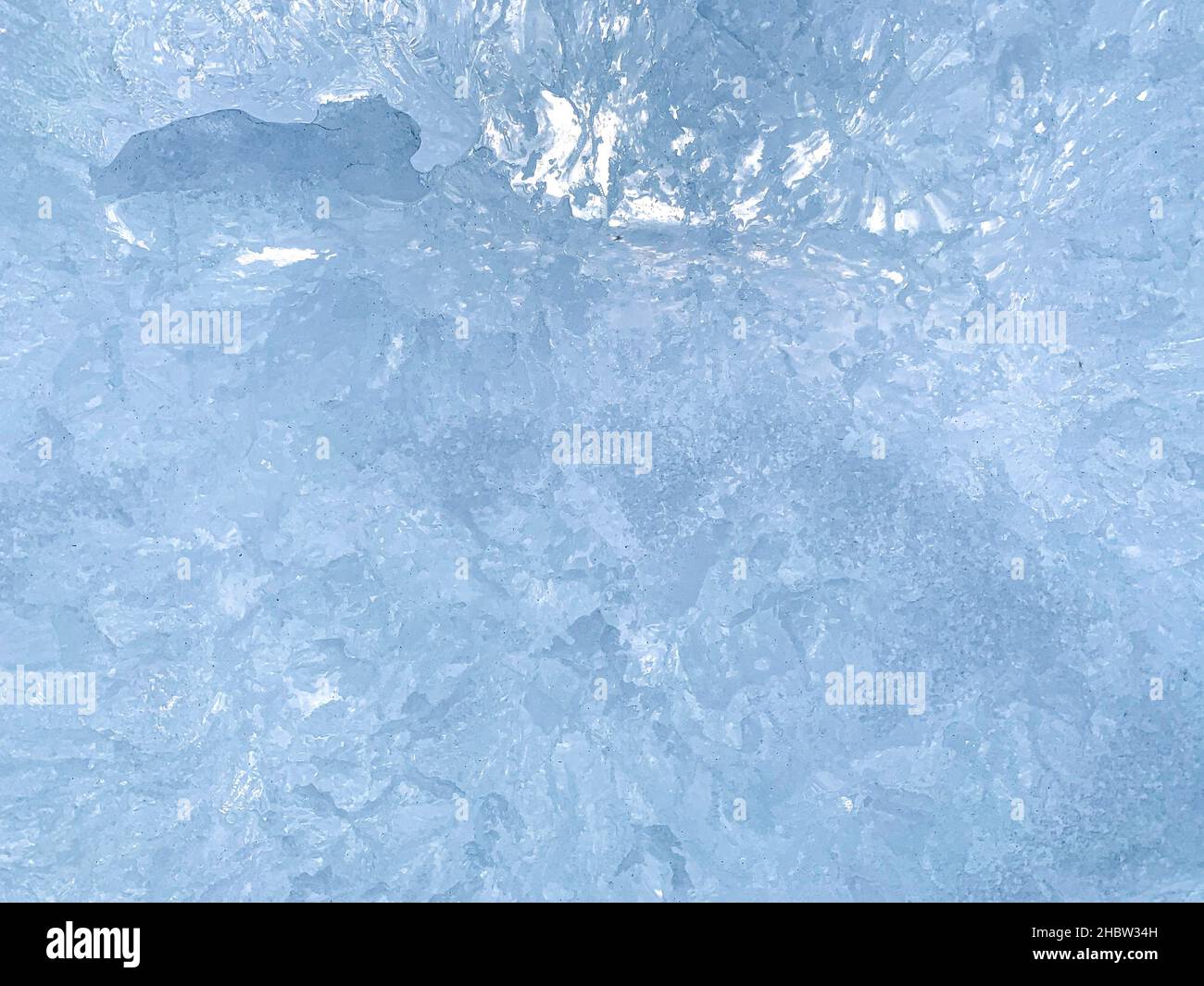 Un arrière-plan abstrait relativement uniforme avec des stries bleues et des cristaux de glace transparents dans un fragment à une seule tranche. Banque D'Images